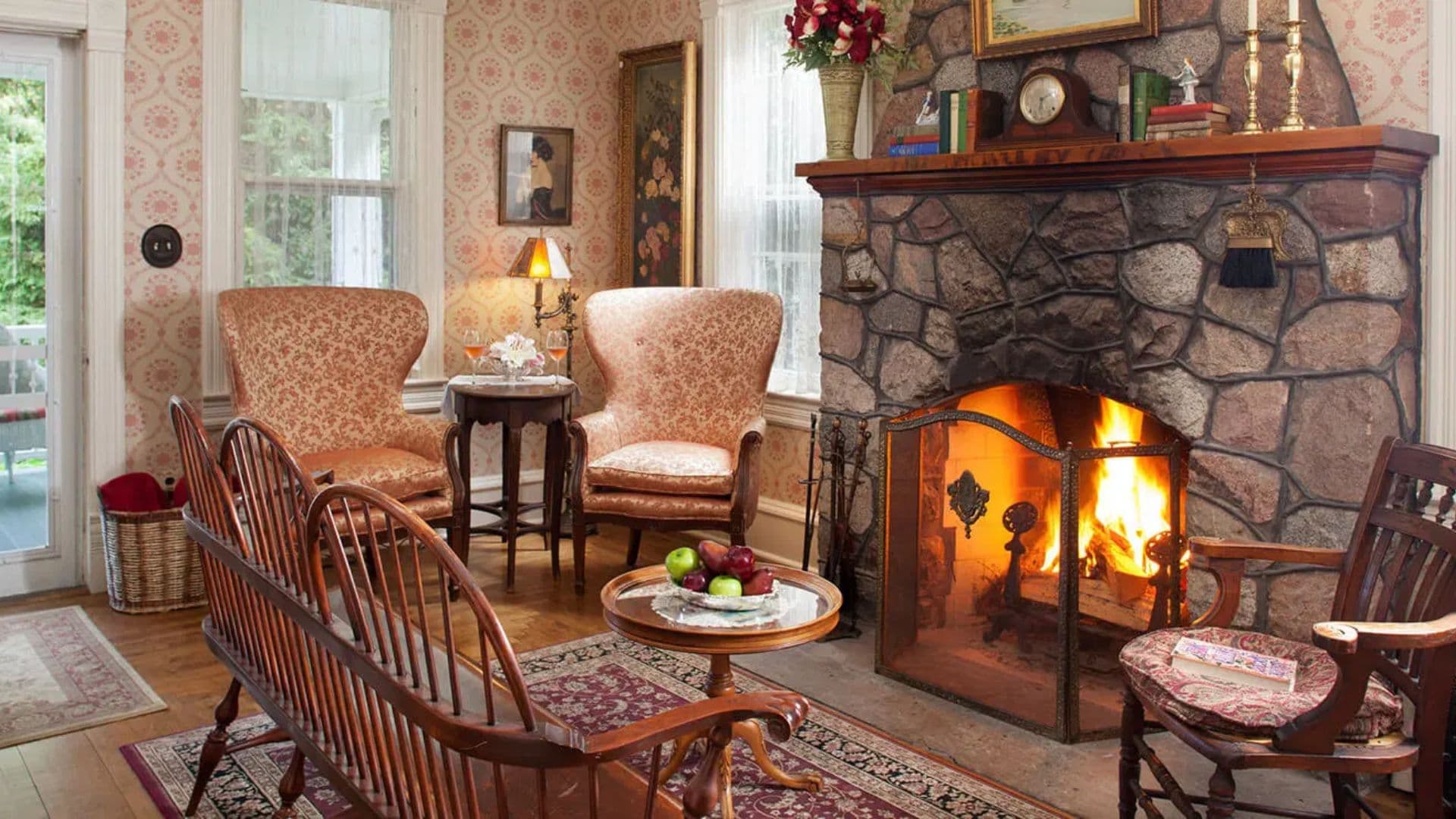 Cozy living room with a stone fireplace, plush armchairs, and a small coffee table.