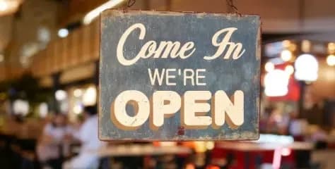 A sign at a restaurant that says "Come in We're Open" A sign at a restaurant that says "Come in We're Open"